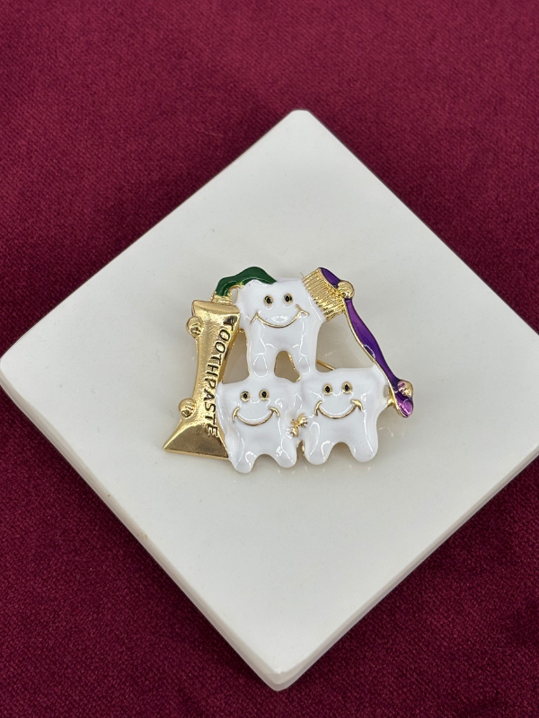 Mor,Beyaz ve Yeşil Renkli Üç Beyaz Diş Figürlü Gold Broş